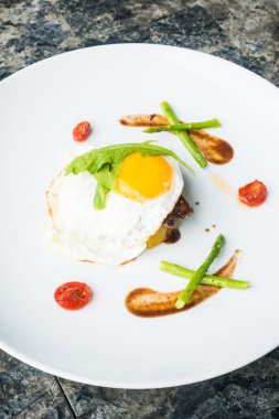 Beyaz tabak içinde kızarmış yumurta