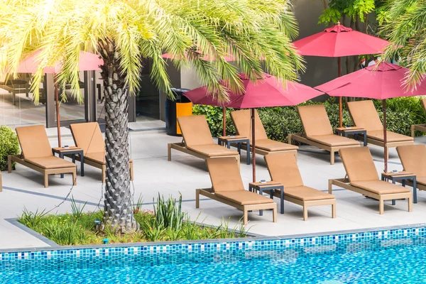 Umbrellas and chairs around swimming pool — Stock Photo, Image