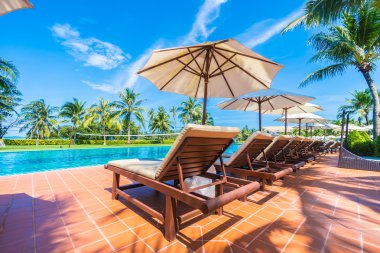 Şemsiyeleri ve sandalyeler Yüzme Havuzu etrafında