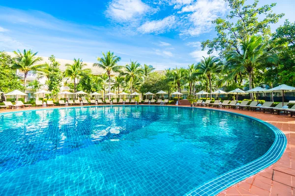 Umbrellas and chairs around swimming pool — Stock Photo, Image