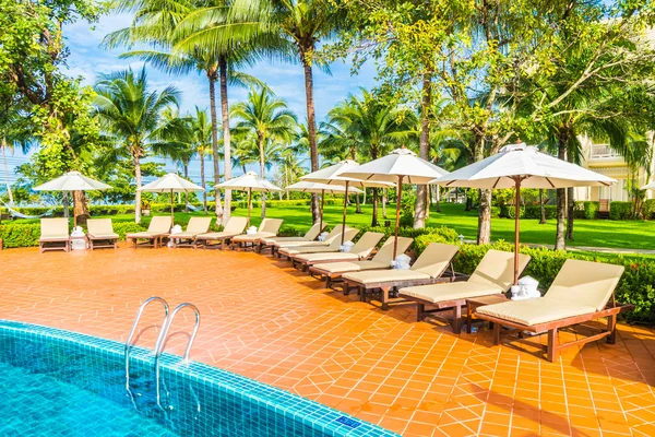 Guarda-chuvas e cadeiras em torno da piscina — Fotografia de Stock