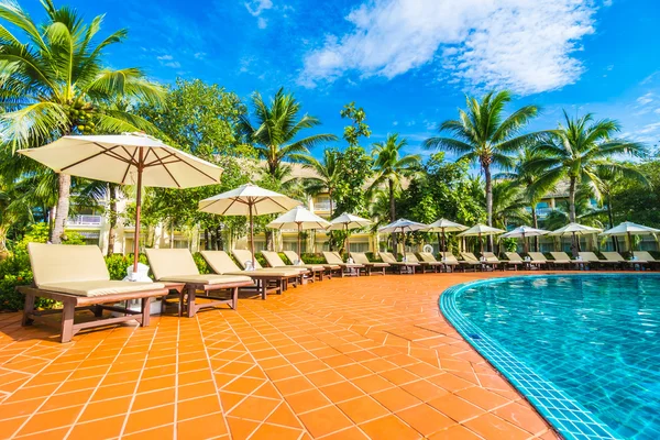 Guarda-chuva e cadeira em torno da piscina — Fotografia de Stock