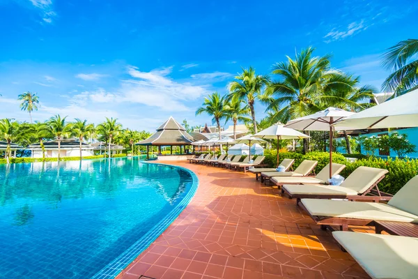 Paraguas y silla alrededor de la piscina — Foto de Stock