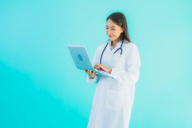 Bilgisayarlı güzel Asyalı doktor kadın portresi klinikte ya da mavi izole arka planda hastanede kullanılacak.