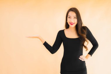 Güzel Asyalı genç bir kadının portresi mutlu bir gülücük renkle izole edilmiş arka planda.