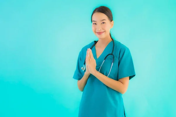 Portrait beautiful young asian doctor woman happy smile with sawasdee for work in hospital and clinic on blue isolated background