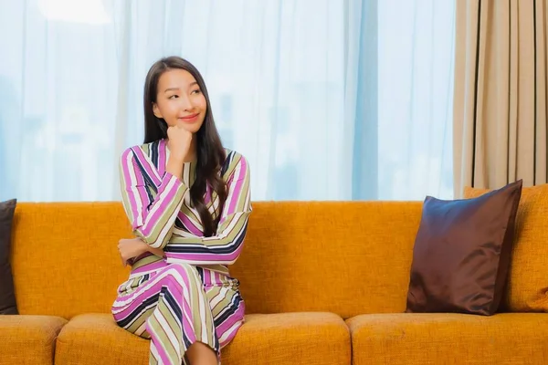 肖像画美しい若いアジアの女性はリラックスしたソファの上にリビングルームのインテリア — ストック写真