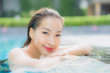 Güzel bir Asyalı kadın portresi. Rahatlayın. Yüzme havuzunda gülümseyin.