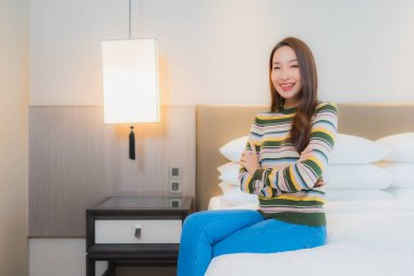 Güzel bir Asyalı kadın portresi. Mutlu bir gülümseme. Yatak odasında iç tarafta rahatla.