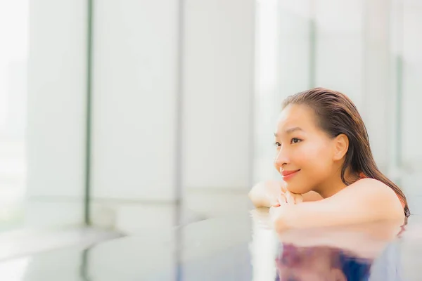 Portrait beautiful young asian woman relax smile around outdoor swimming pool in hotel resort