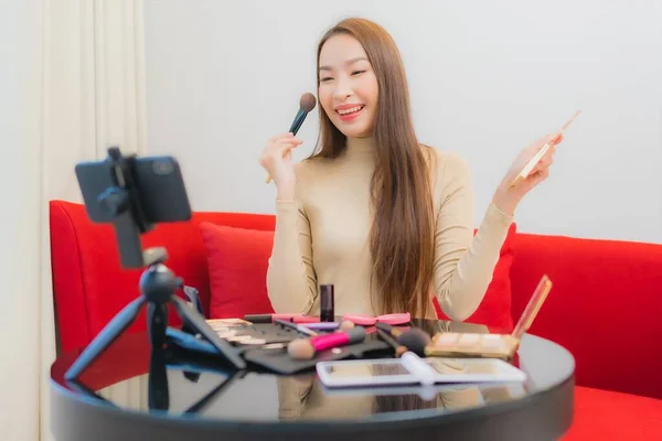 美容美发的年轻亚洲女人在客厅的沙发上评论和使用化妆品 — 图库照片