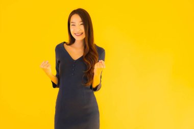 İzole edilmiş sarı arka planda hareketli güzel Asyalı kadın portresi.