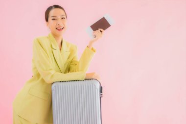 Güzel Asyalı iş kadını portresi, bavul çantası ve pasaport renginde.