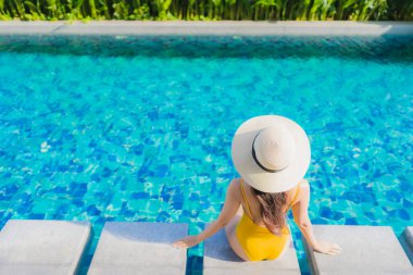 Güzel bir Asyalı kadın portresi. Rahatlayın. Keyifli bir tatil için oteldeki yüzme havuzunda mutlu bir gülümseme.