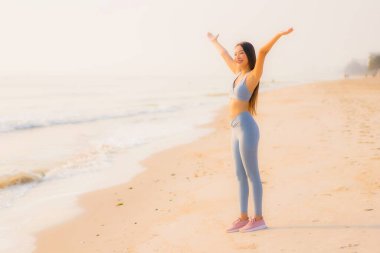 Portre sporu genç Asyalı kadın egzersiz hazırlıyor ya da sağlık için okyanusta koşuyor.