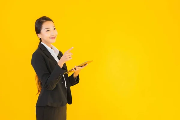 肖像画美しい若いアジアの女性幸せな笑顔とともにスマートタブレットデバイス上の黄色隔離された背景 — ストック写真
