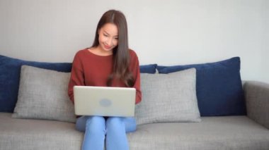 Evde dizüstü bilgisayarla çalışan Asyalı güzel bir kadının görüntüleri.