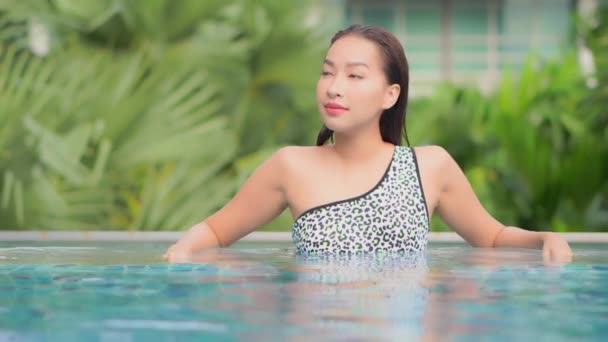 在酒店度假胜地的室外游泳池周围 年轻美丽的亚洲女子在放松微笑 — 图库视频影像