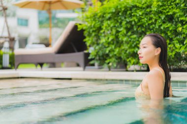 Güzel bir Asyalı kadın portresi. Rahatlayın. Yüzme havuzunda gülümseyin.