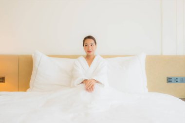 Güzel bir Asyalı kadının portresi. Gülümse. Yatak odasında rahatla.