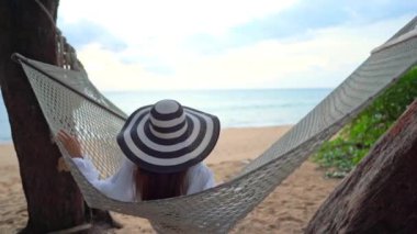 Güzel Asyalı kadının yaz tatilinde deniz kıyısında dinlendiği görüntüler.