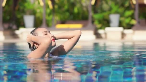 美丽的年轻亚洲女人在酒店度假胜地的室外游泳池周围放松一下 — 图库视频影像