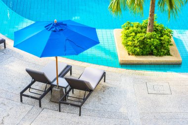 Güzel boş sandalye ve şemsiyeli açık havuz oteldeki tatil gezisi için.
