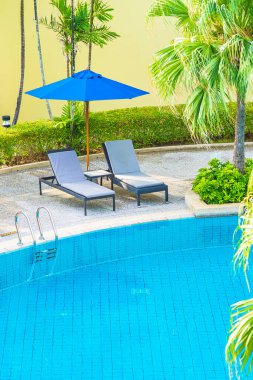 Güzel boş sandalye ve şemsiyeli açık havuz oteldeki tatil gezisi için.