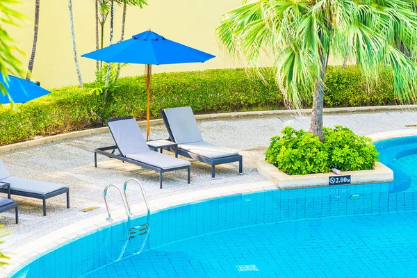 Güzel boş sandalye ve şemsiyeli açık havuz oteldeki tatil gezisi için.