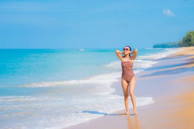 Güzel bir Asyalı kadın portresi. Rahatla. Deniz kıyısı okyanusunda rahatça gülümse.