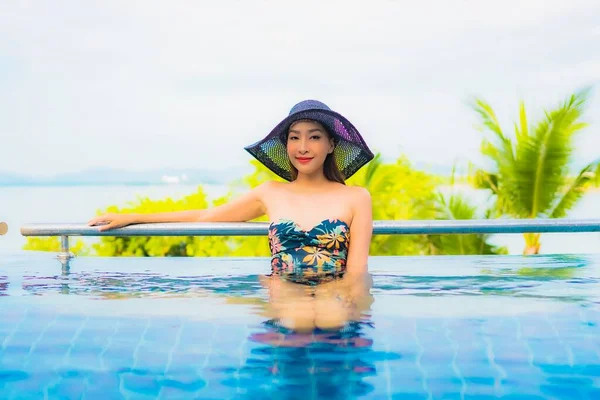 美しい若いアジアの女性の肖像旅行休暇のための海の景色を屋外スイミングプールの周りの笑顔のレジャーをリラックス — ストック写真