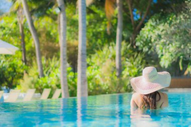 Güzel bir Asyalı kadın portresi. Mutlu bir gülümseme. Keyifli bir tatil için otel havuzunda rahatça yüzme havuzu.