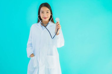 Klinikte ya da mavi izole edilmiş arka planda hastanede kullanmak üzere steteskoplu güzel Asyalı genç doktor kadın portresi.