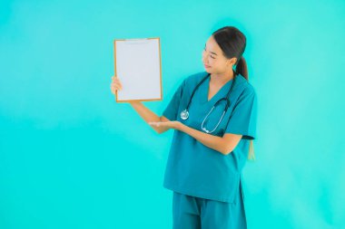 Fotokopi için boş kâğıt tahtası olan güzel Asyalı genç doktor kadın hastane ve klinikteki sağlık hizmetleri konseptinde mavi izole edilmiş arka plan.
