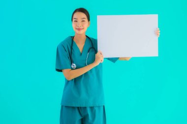 Fotokopi için boş kâğıt tahtası olan güzel Asyalı genç doktor kadın hastane ve klinikteki sağlık hizmetleri konseptinde mavi izole edilmiş arka plan.