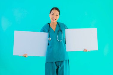 Fotokopi için boş kâğıt tahtası olan güzel Asyalı genç doktor kadın hastane ve klinikteki sağlık hizmetleri konseptinde mavi izole edilmiş arka plan.