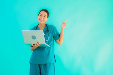 Mavi izole arka planda dizüstü bilgisayarı olan güzel Asyalı doktor kadın portresi.