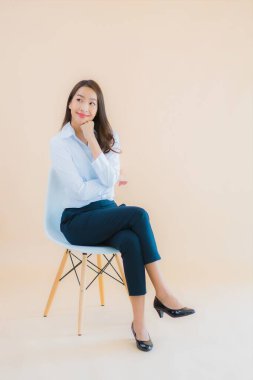 Güzel bir iş kadını portresi. Sandalyeye dizüstü bilgisayarı ya da iş için akıllı telefonu olan bir kadın.