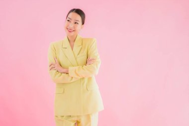 Portre güzel Asyalı genç iş kadını pembe arka planda gülümsüyor