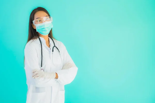 Portrait beautiful young asian doctor woman with mask work at clinic or hospital on blue isolated background