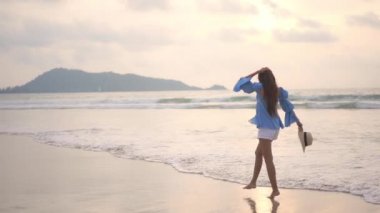 Güzel Asyalı kadının yaz tatilinde deniz kıyısında dinlendiği görüntüler.