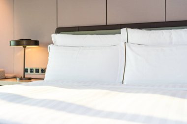 Yatak odasının iç kısımlarında beyaz rahat yastık ve battaniye.