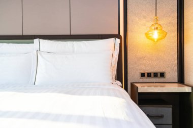 Yatak odasının iç kısımlarında beyaz rahat yastık ve battaniye.