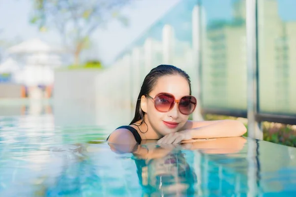 美しい若いアジアの女性がホテルのリゾートで屋外スイミングプールの周りで笑顔をリラックス — ストック写真