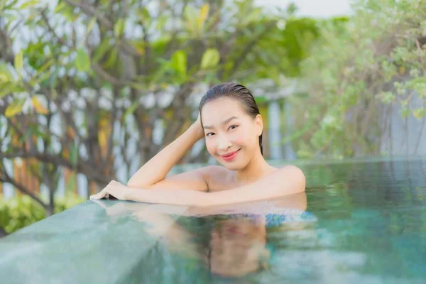 ポートレートの美しい若いアジアの女性は旅行休暇で海のビーチの近くの屋外スイミングプールの周りの笑顔レジャーをリラックス — ストック写真