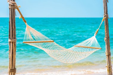 Boş bir tatil konsepti için deniz kıyısındaki boş bir hamak.