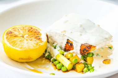 Izgara somon balığı bifteği, sebze ve limonlu beyaz tabak, sağlıklı yiyecek.