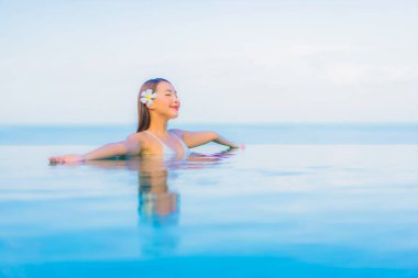 Güzel bir Asyalı kadın portresi. Rahat ol. Yüzme havuzu etrafında gülümse.