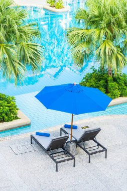 Şemsiye ve sandalye, tatil için otel tatil beldesindeki yüzme havuzunda.