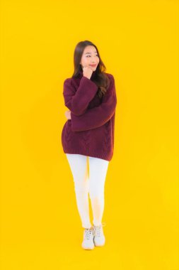 Güzel Asyalı kadın gülümsüyor. Sarı izole edilmiş arka planda başka bir eylemde mutlu.